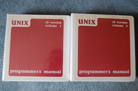 Two red books containing Volume 1 and 2 of Programmers Manuals for CB Unix